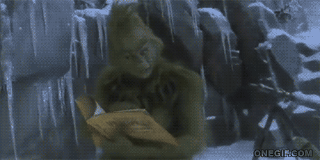 El Grinch emocionado con libro que se compró en la Feria del Libro.